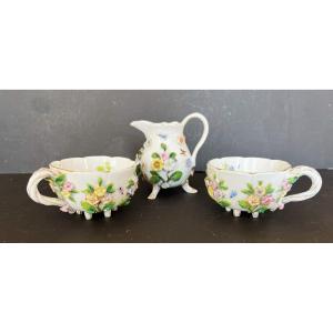 Deux Tasses Et Un Pot à Lait En Porcelaine à Décor De Fleurs En Relief Et d'Insectes.