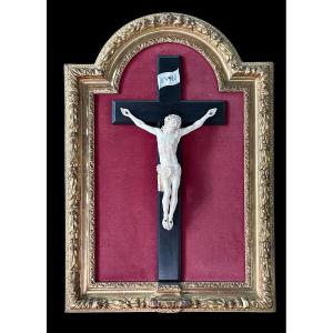 Christ en ivoire sur une croix en ébène et cadre façonné en feuille d'or 