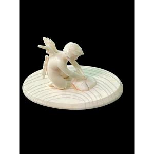 Small Ivory Sculpture Depicting Cupid Sharpening His Arrow. 