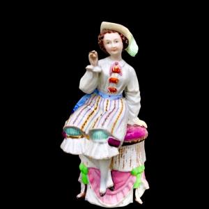 Boîte à tabac en porcelaine à décor d'une figure féminine assise avec un cigare. 