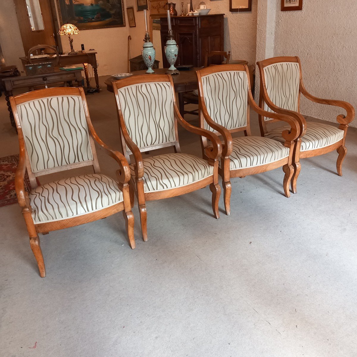 Suite de quatre fauteuils "à crosses", époque Restauration, en noyer blond.