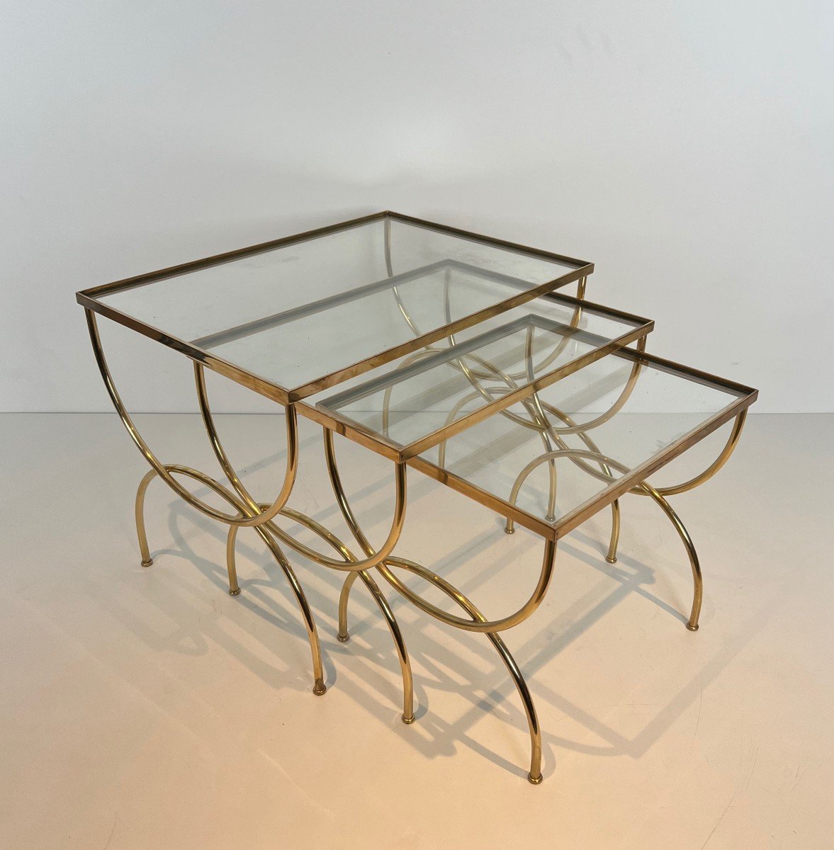 Neoclassical Style Brass Nesting Tables With Arcuate Base. French Work. Circa 1940