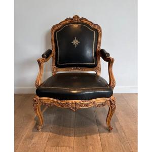 Fauteuil à La Reine En Noyer Sculpté Garni De Cuir Noir à Bordure Et Décor Doré Au Fer. 