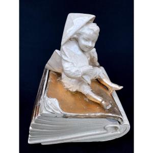 Earthenware Of A Book And A Child In A Paper Hat