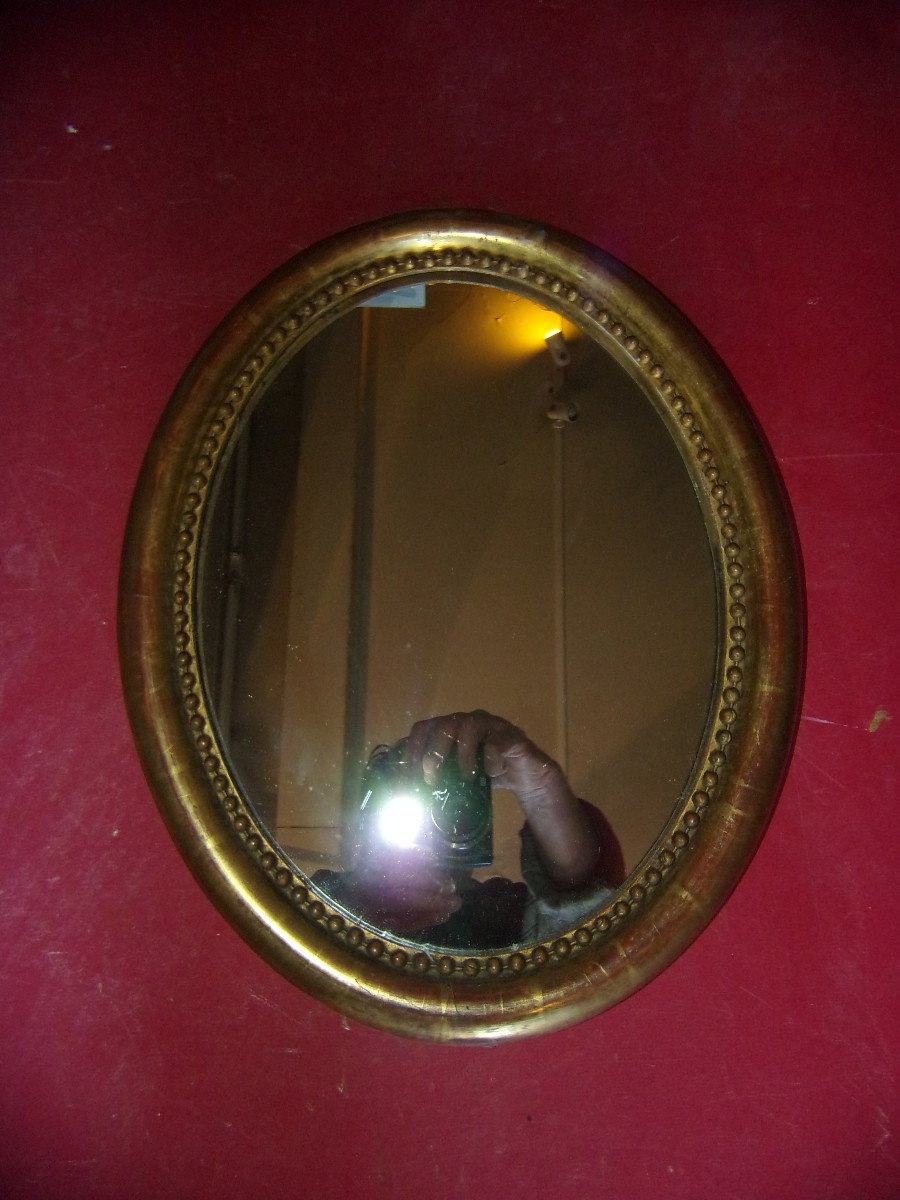 Small Oval Mirror From The 19th Century, In Gilded Wood.