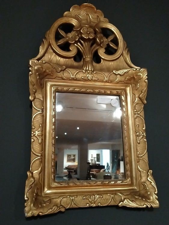 Mirror In Gilded And Carved Wood. Floral Motifs Adorn The Rich Coping