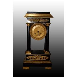 French Clock From The Mid-1800s In Empire Style, Ebonized Wood, With Rich Bronze Applications