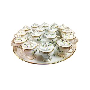 Bel ensemble composé d’un plateau et de 16 pots à crème en porcelaine, décor au barbeau