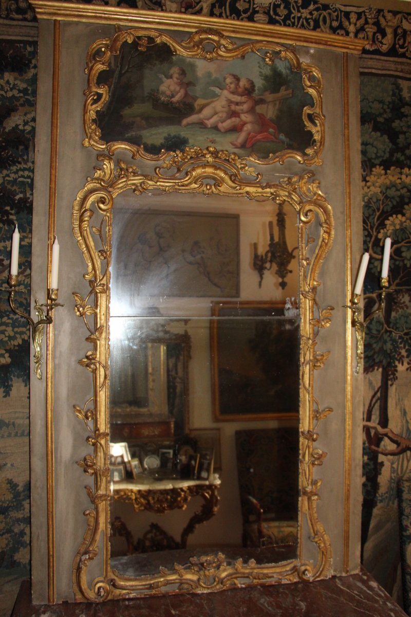 Trumeau sculpté de bois dorés, décoré d'une toile aux puttis, époque Louis XV, XVIIIe siècle.