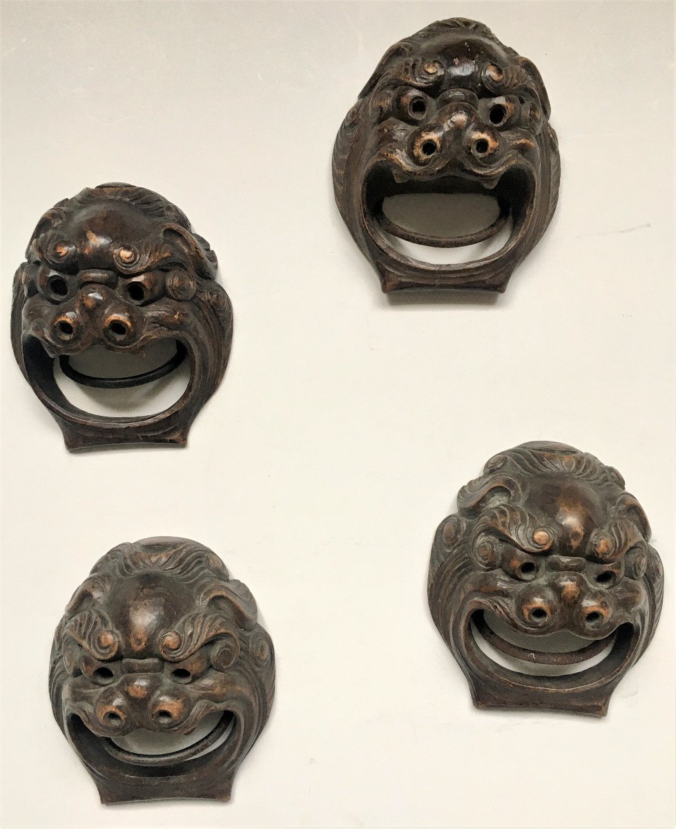 Quatre mascarons en bois sculpté. "Chiens Fô". Chine début XX°.