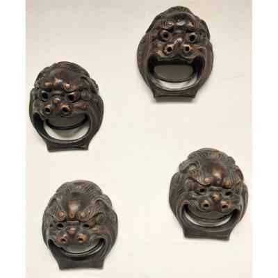 Quatre mascarons en bois sculpté. "Chiens Fô". Chine début XX°.