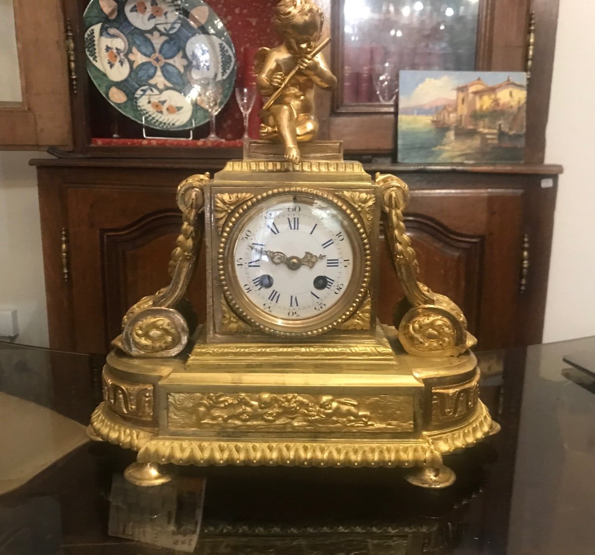 Restoration Clock In Gilt Bronze Topped With A « putti » Playing The Flute