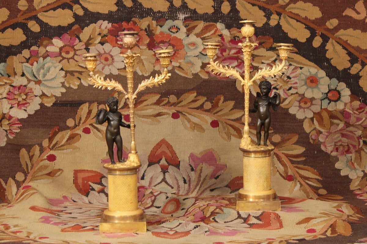 Paire de candélabres à trois lumières orné d'un Cupidon, bronze doré et patiné, XIXème siècle 