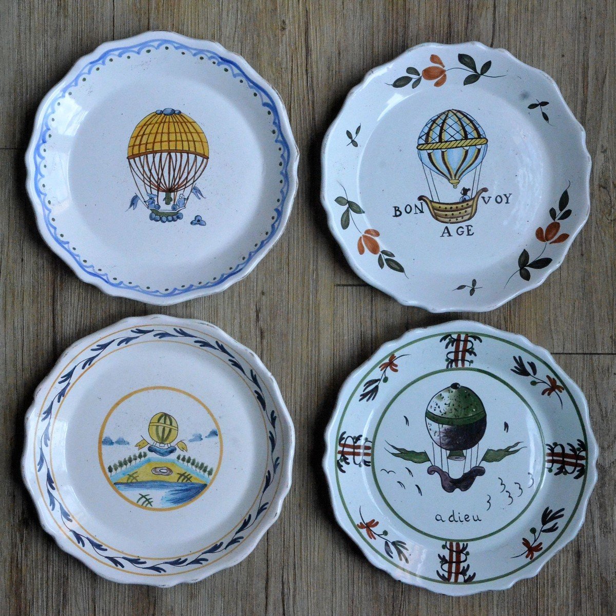 Suite de quatre assiettes aux montgolfières. Nevers