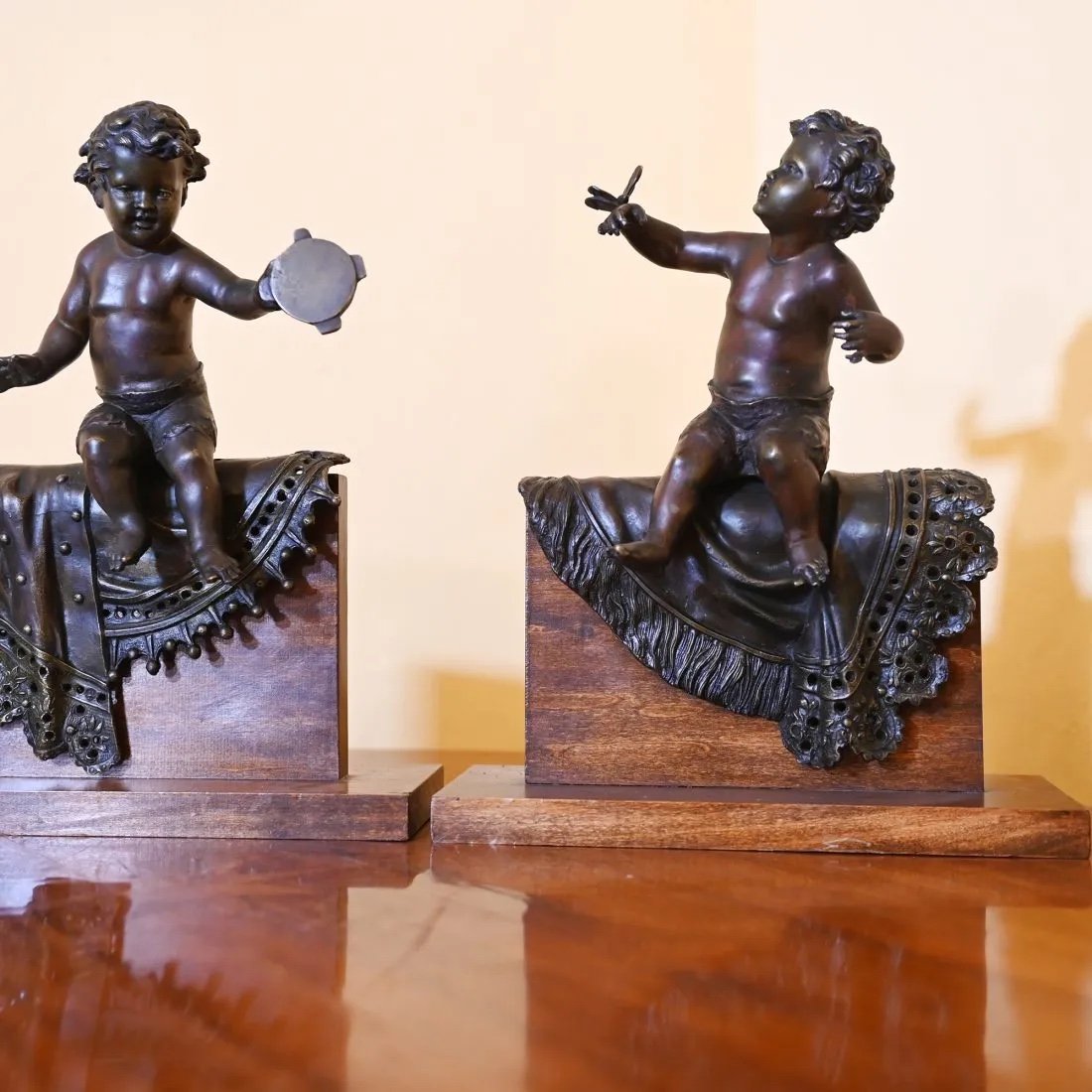 Pair Of Bronze Sculptures With A Burnished  Patina. Two Cherubs Lying On A Richly Decorate Bla -photo-2