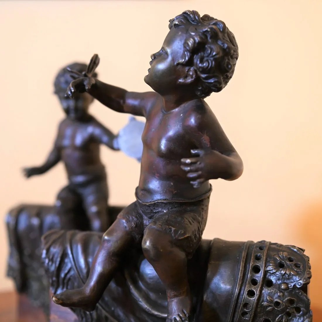 Pair Of Bronze Sculptures With A Burnished  Patina. Two Cherubs Lying On A Richly Decorate Bla -photo-3