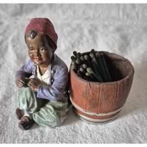 Orientalist Subject Boy Seated Beside A Barrel Forming A Pyrogenic Match Holder 