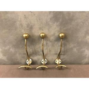 Set Of Three Coat Hooks In Polished And Varnished Brass From The 19th Century. 