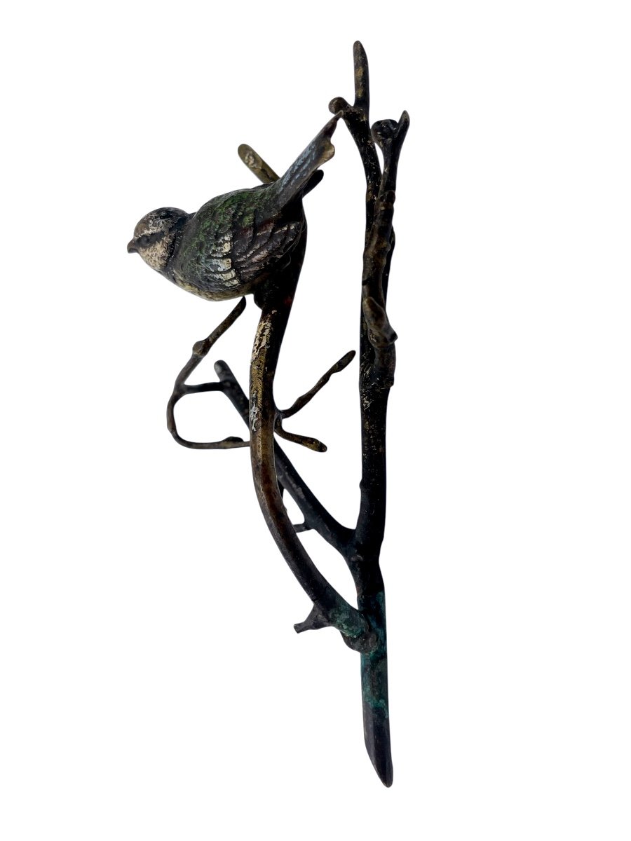 Oiseau en bronze avec peinture émaillée, posé sur une branche.-photo-1