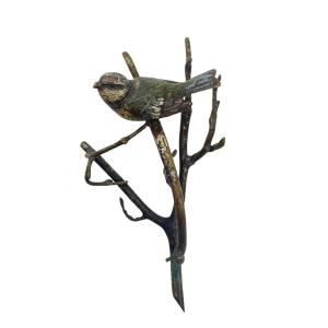 Oiseau en bronze avec peinture émaillée, posé sur une branche.