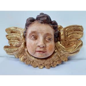 Tête d'ange en bois sculpté peint et doré.