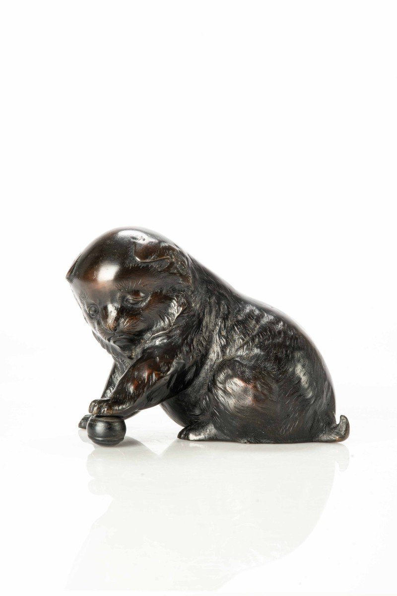 A Bronze Okimono Depicting A Study Of A Puppy Playing With A Ball