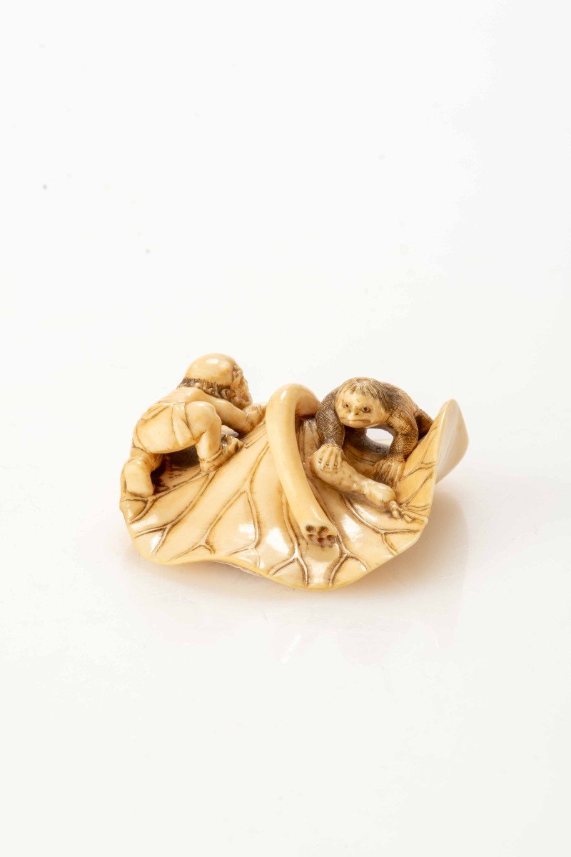 Netsuke En Ivoire Figurant Un Oni Et Un Kappa Sur Une Feuille De Lotus Géante