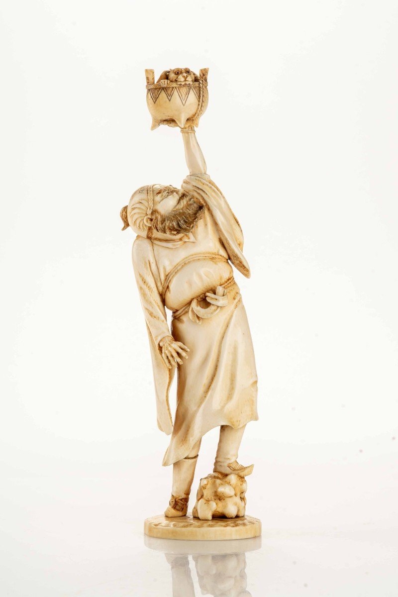 An Ivory Okimono Depicting A Standing Shoki Holding A Large Koro