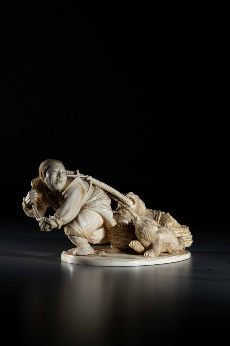 An Ivory Okimono Depicting An Ainu Hunter Dragging A Bear-photo-2