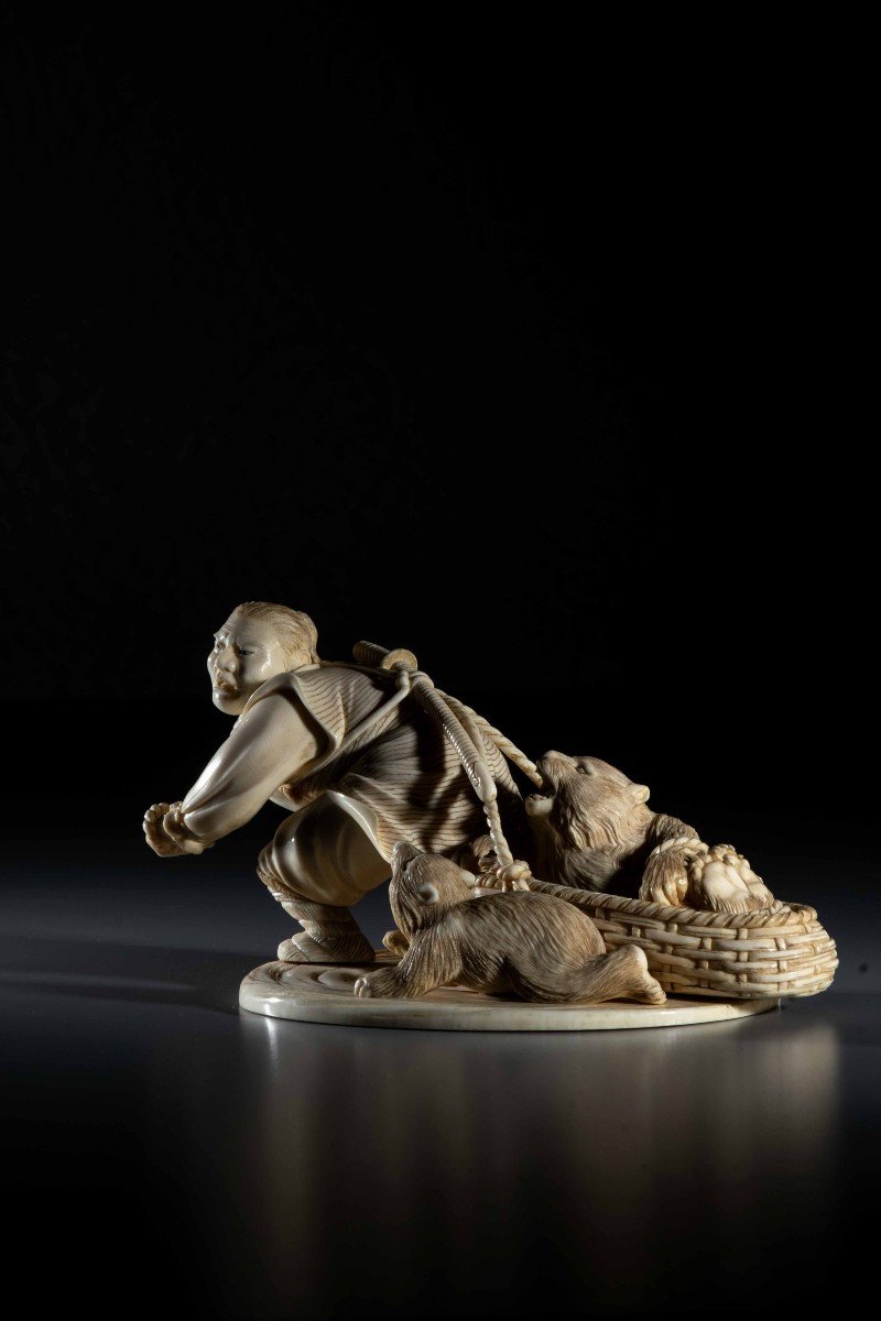 An Ivory Okimono Depicting An Ainu Hunter Dragging A Bear-photo-2