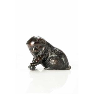 A Bronze Okimono Depicting A Study Of A Puppy Playing With A Ball