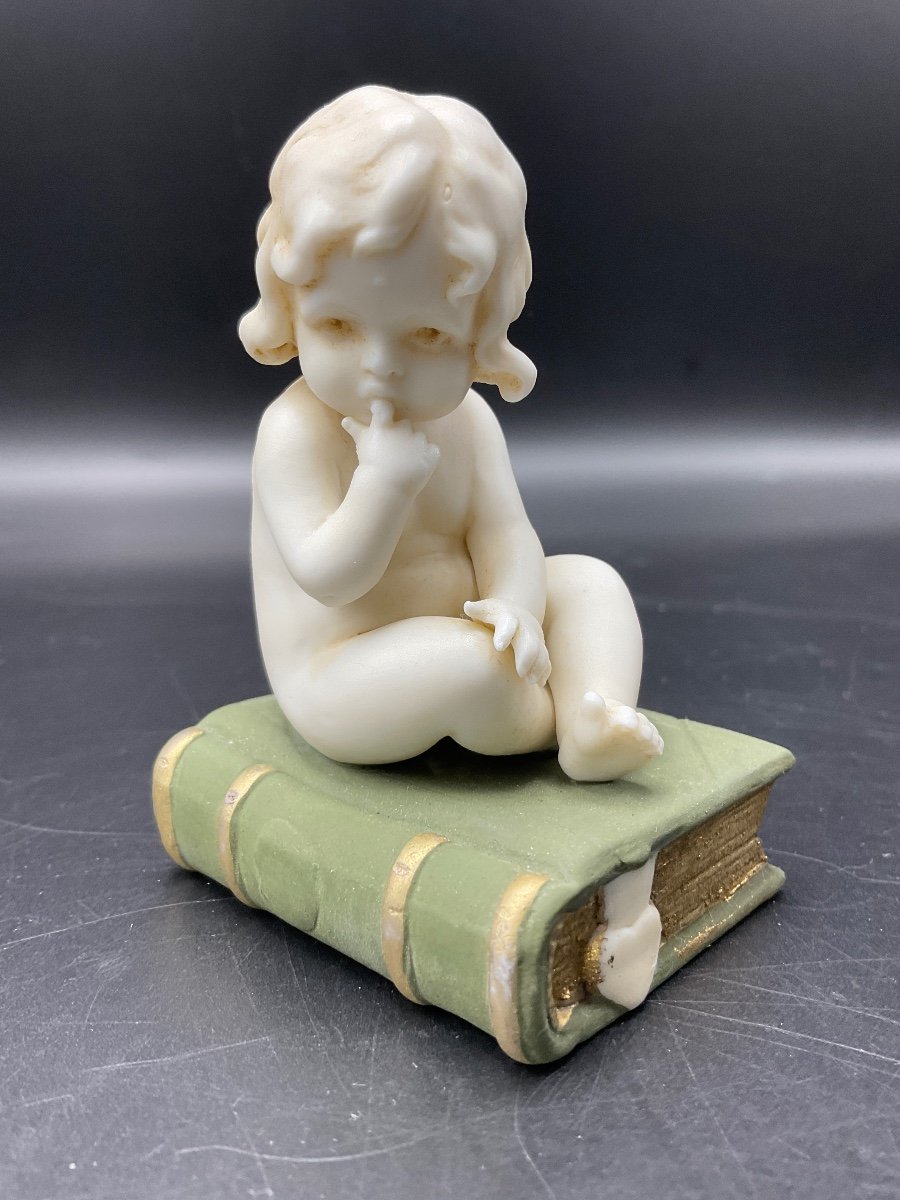 Biscuit From The Muller Factory Representing A Little Girl Sitting On A Book.