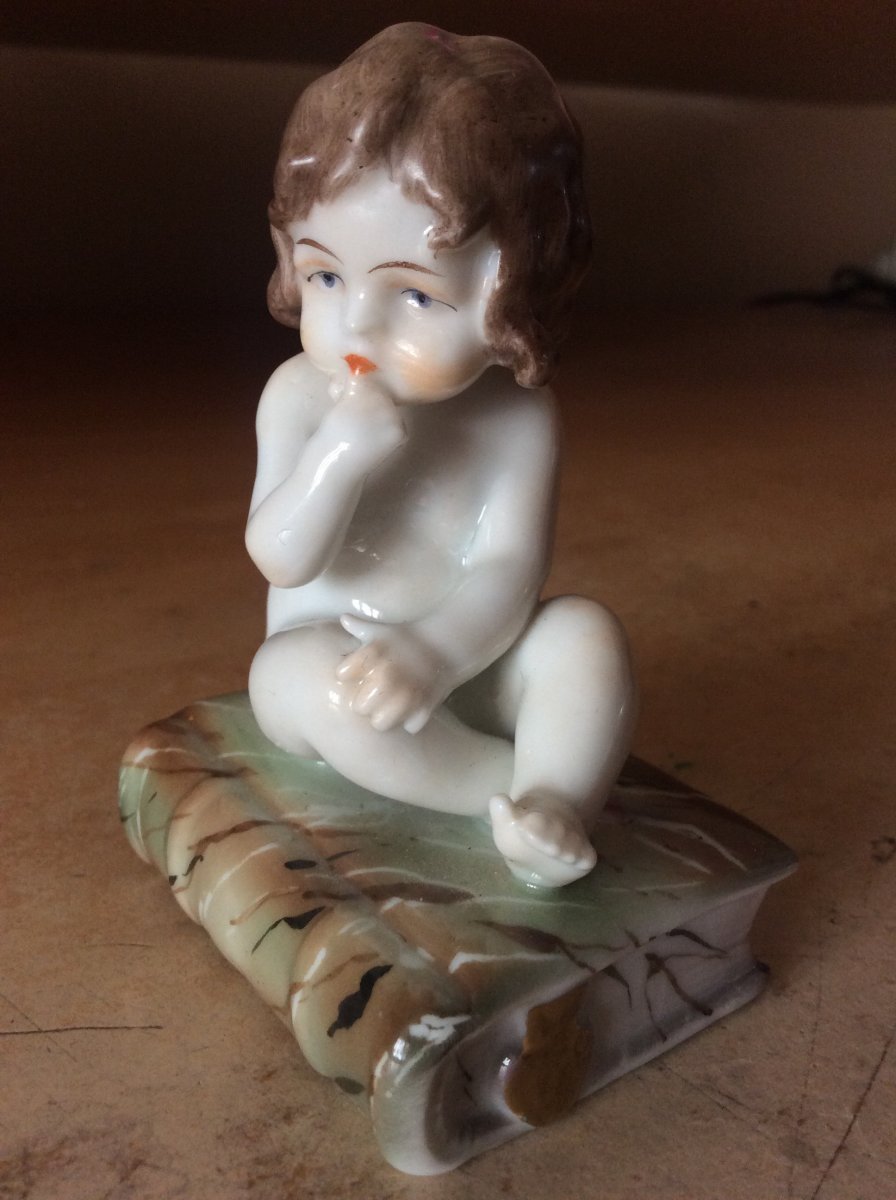 Porcelaine Polychrome De Müller Représentant Une Petite Fille Assise Sur Un Livre.