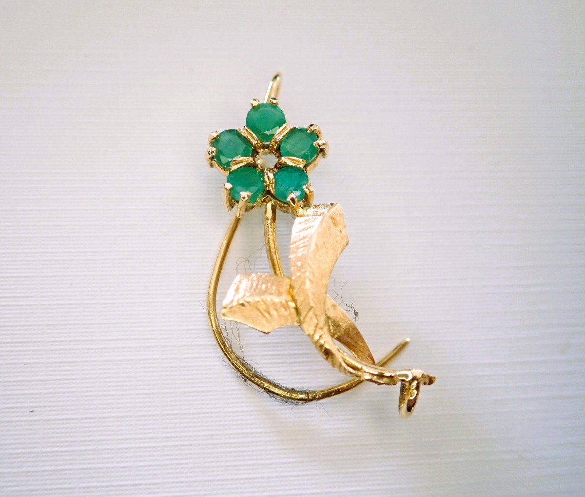 Broche motif fleur sertie d'émeraudes