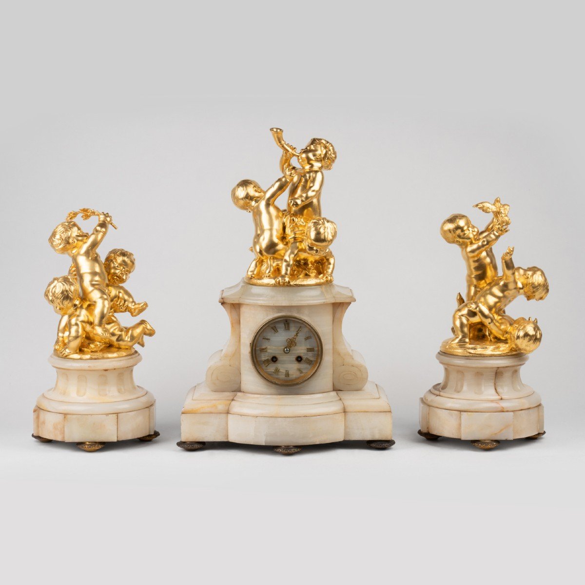 Garniture de chemin&eacute;e en bronze dor&eacute; &agrave; d&eacute;cor de putti et base en onyx, XIXe