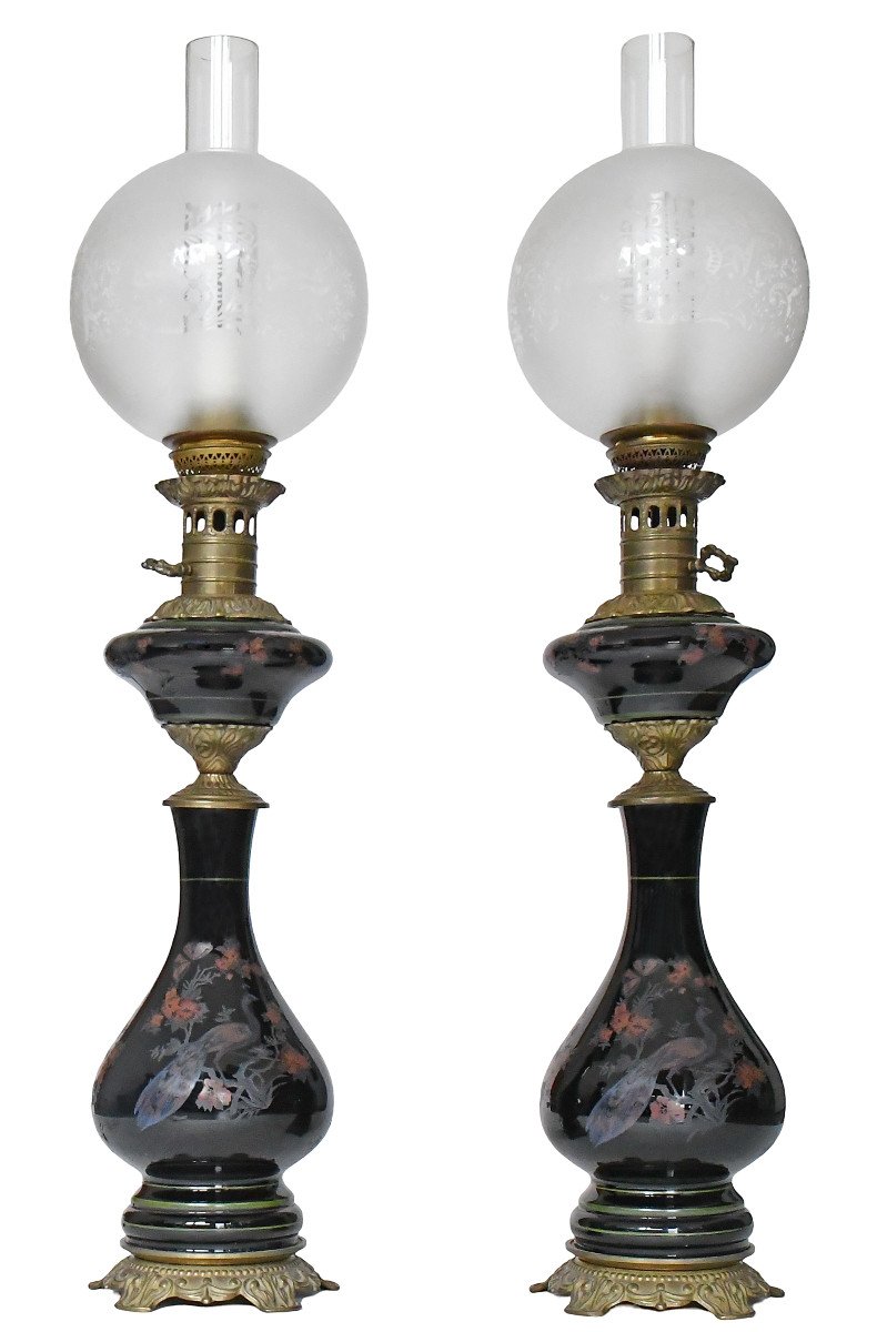 Paire de lampes à pétrole en opaline noire à décor émaillé de paons et de fleurs