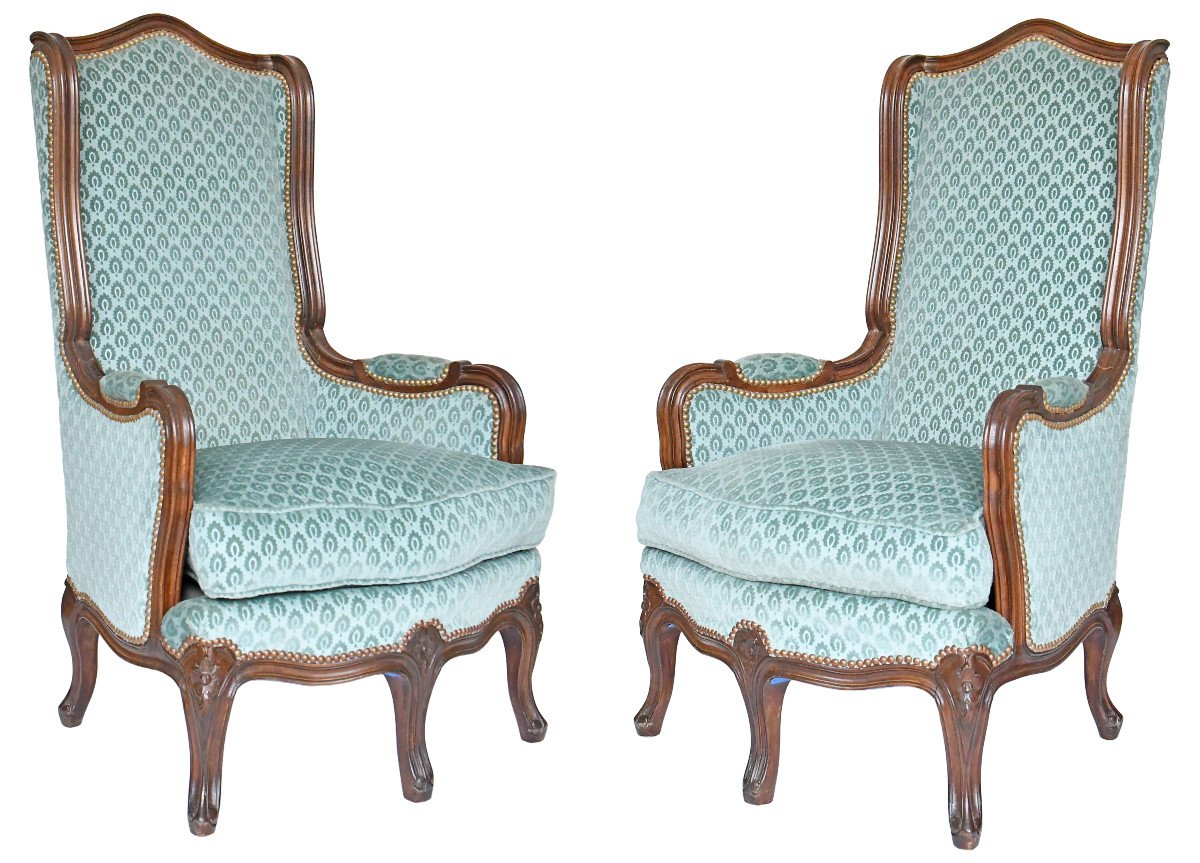 Paire de fauteuils bergères à oreilles de style Louis XV à cinq pieds