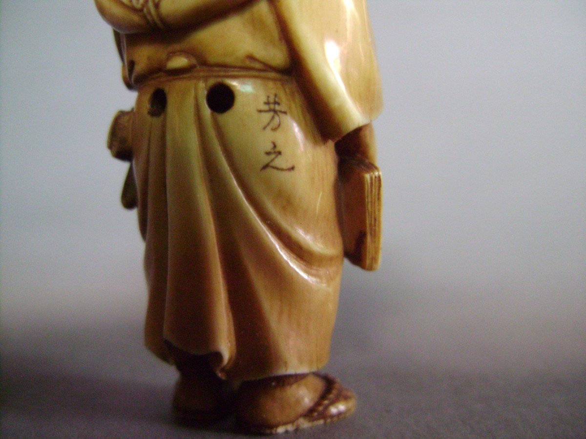 Netsuke en ivoire. Scène de rue. Crieur . Japon époque Meiji (1868-1912 )-photo-1