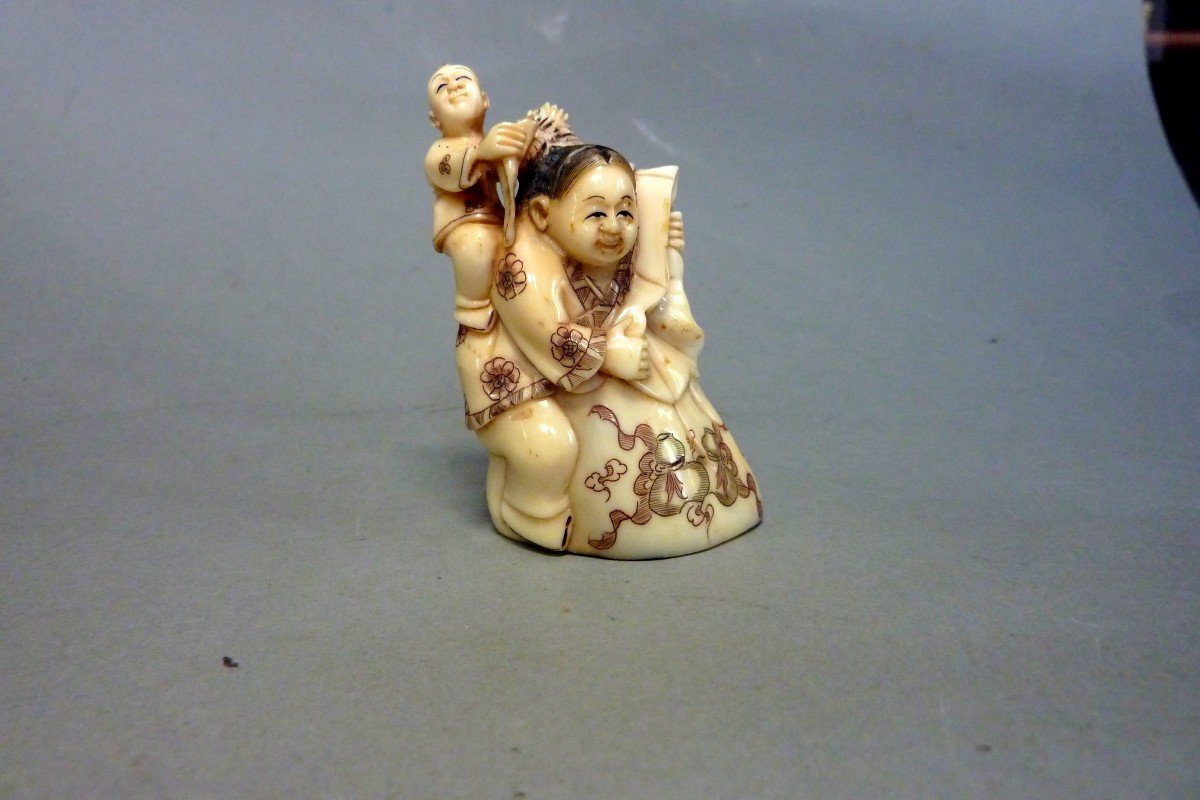 Netsuke en ivoire. Jeune femme au gros sac. Japon époque Taisho (1912-1928)