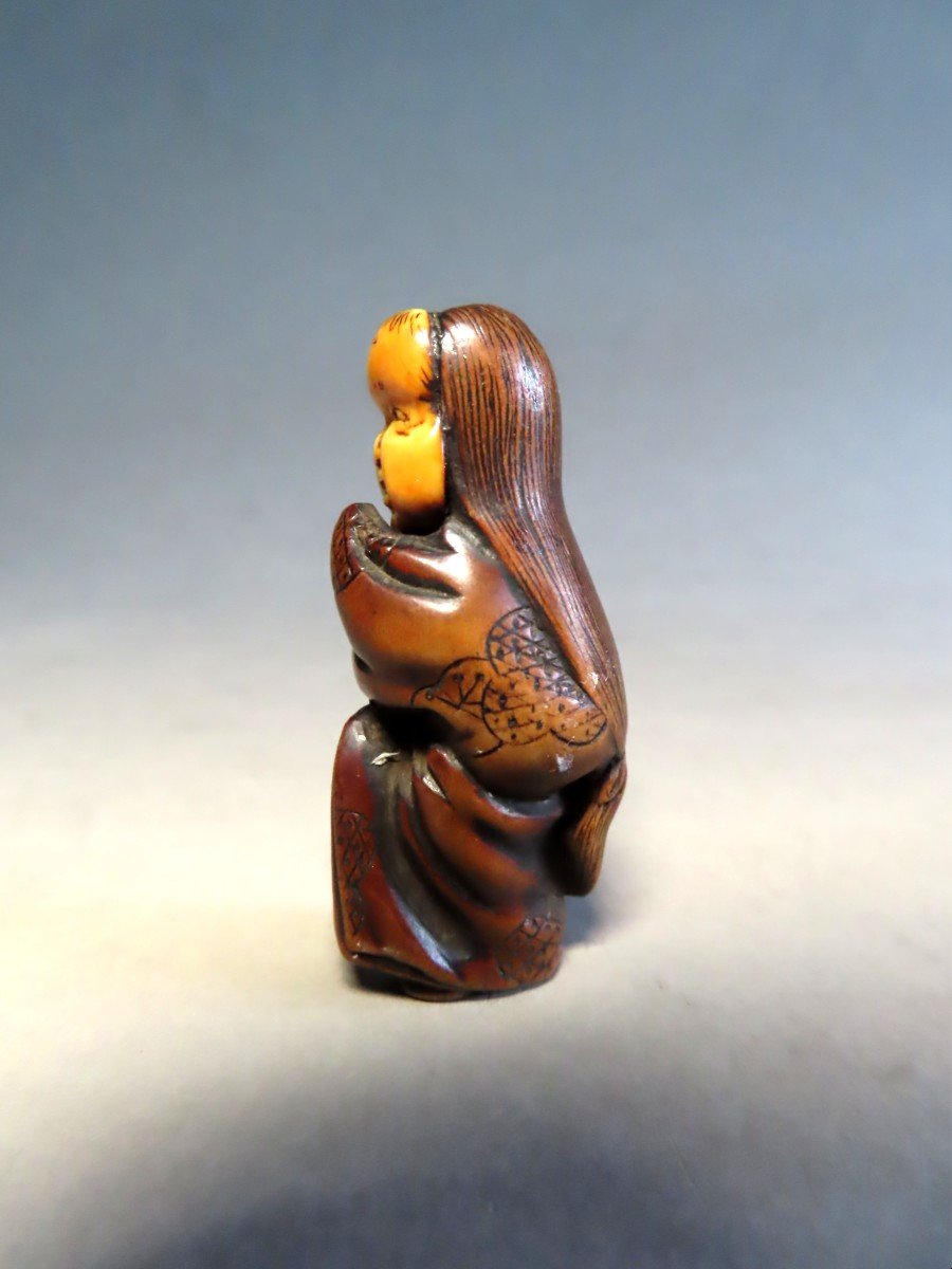 Netsuke bois et ivoire. Jeune femme au masque d'Okame. Japon Meiji.