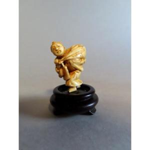 Netsuke en ivoire. Jeune paysanne au baluchon. Japon époque Meiji (1868-1912 )