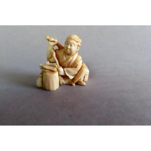 Netsuke en ivoire. Scène de rue. Petit  marchand . Japon époque Meiji (1868-1912 )